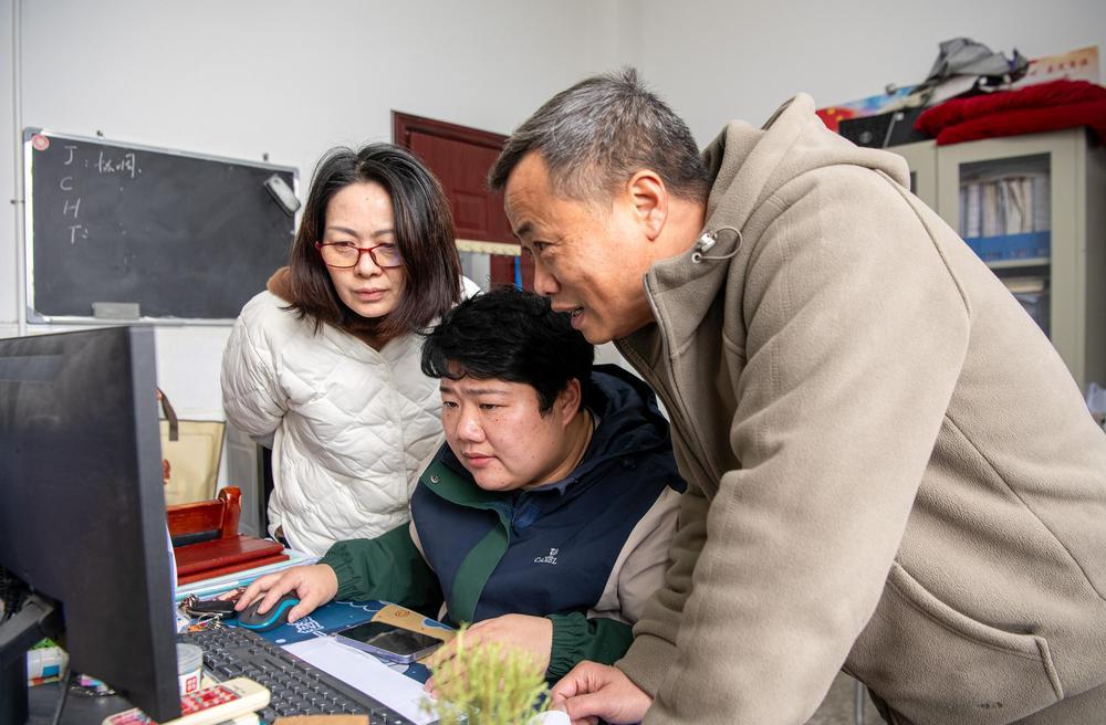 姜婷正和同事讨论教学教研工作安排。